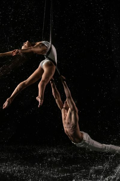 Man stretching his arms in a fluid motion against a dark background.