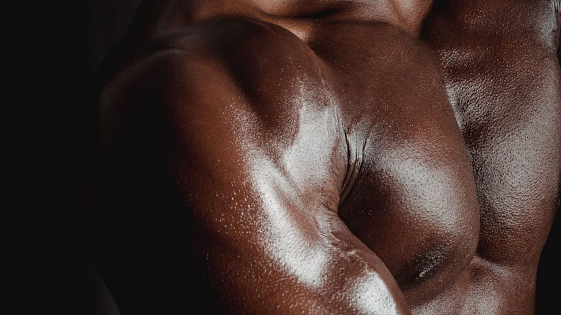 Silhouette of a man in a focused athletic stance in a dark room.